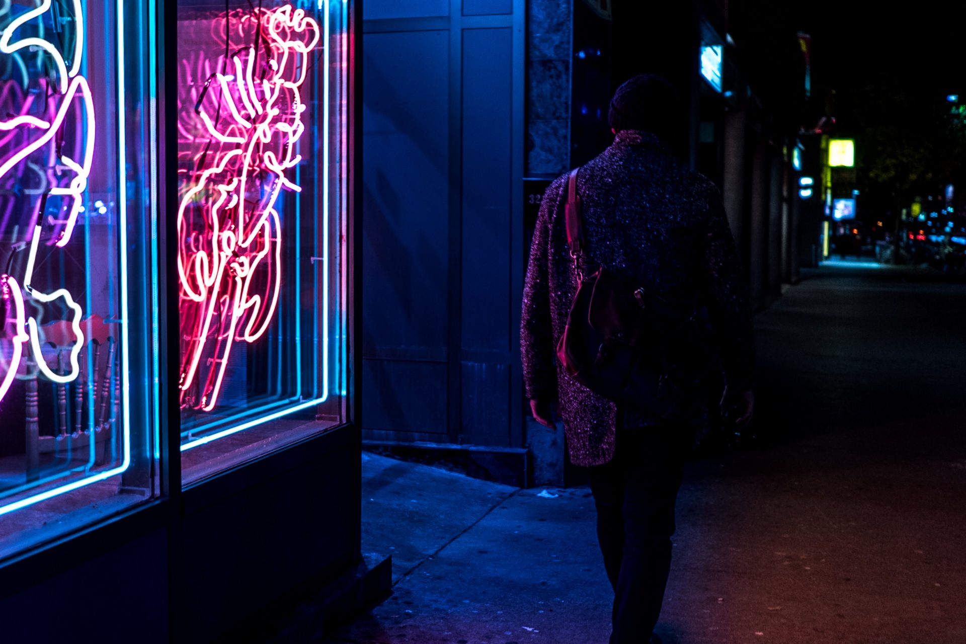 photo of person outside a dimly lit bar at night