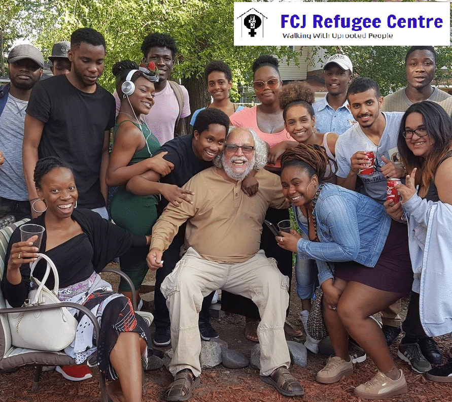 FCG Refugee Centre co-director Francisco Rico Martinez surrounded by community members, smiling into camera