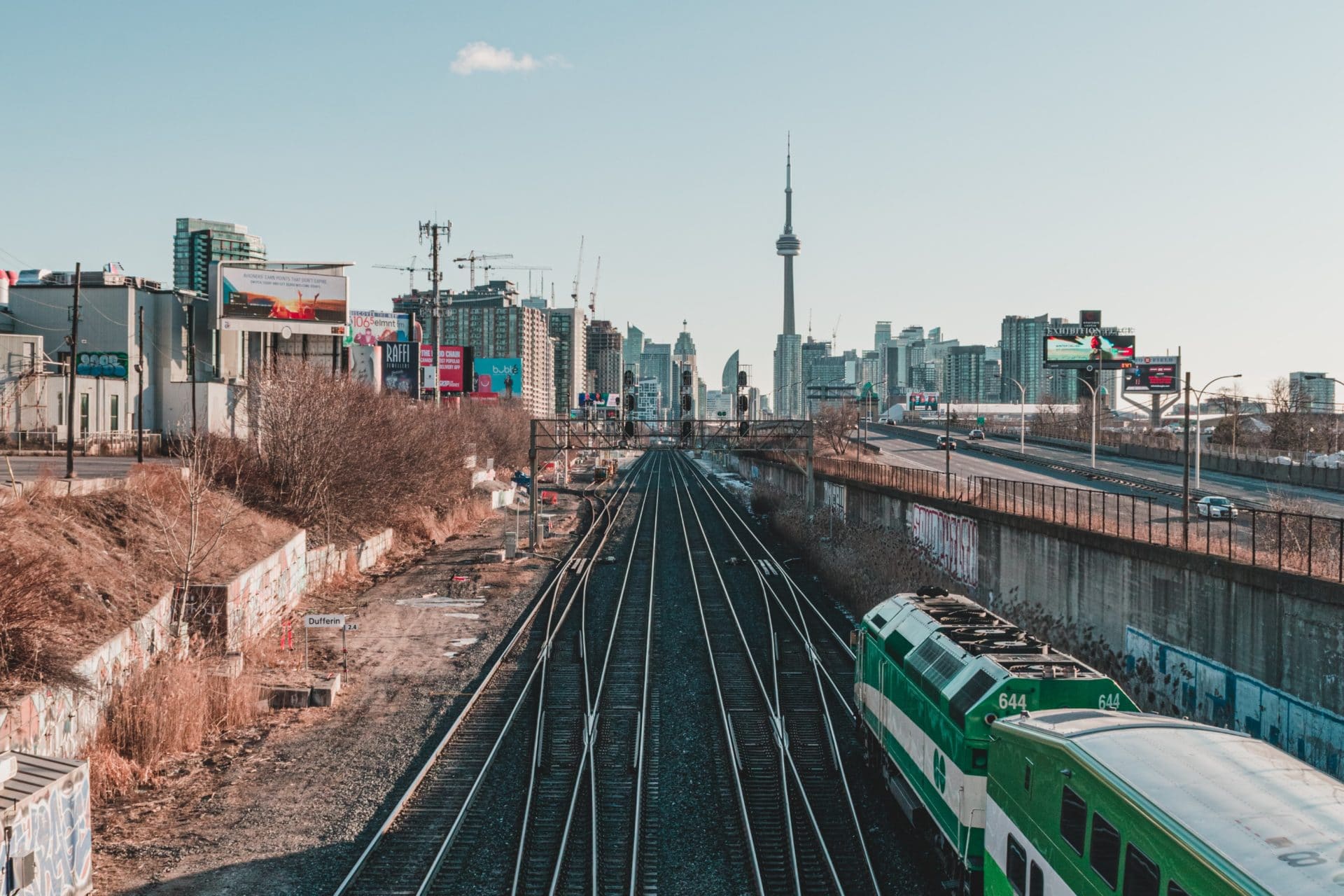 Metrolinx's GO train tracks with GO train in the foreground and CN tower in the background