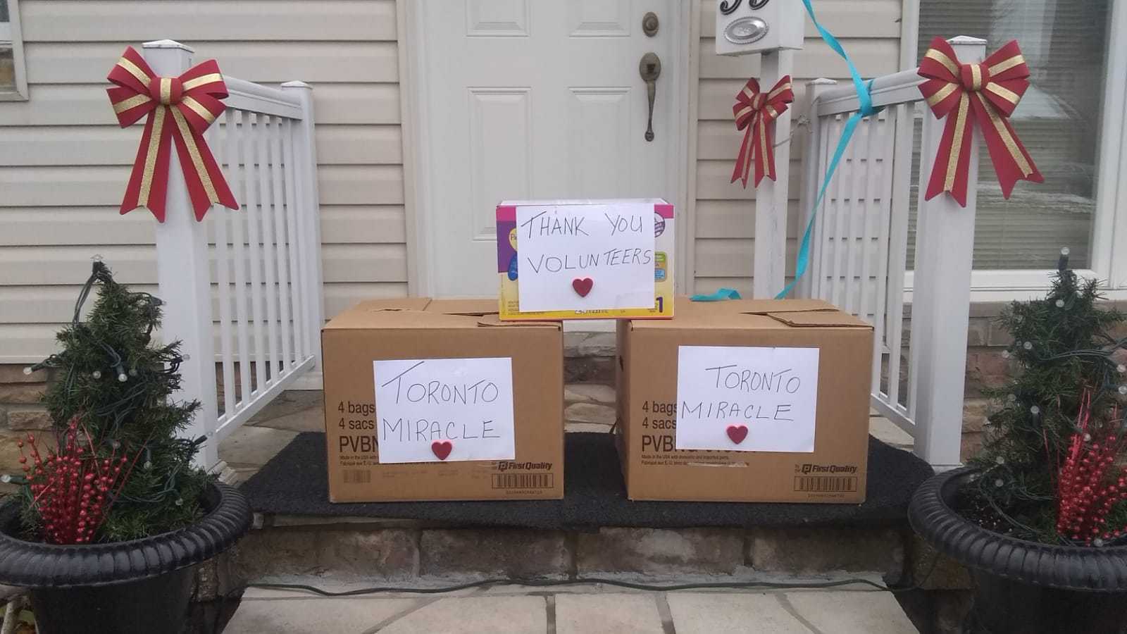 Brown boxes with white paper on them in front of a porch.